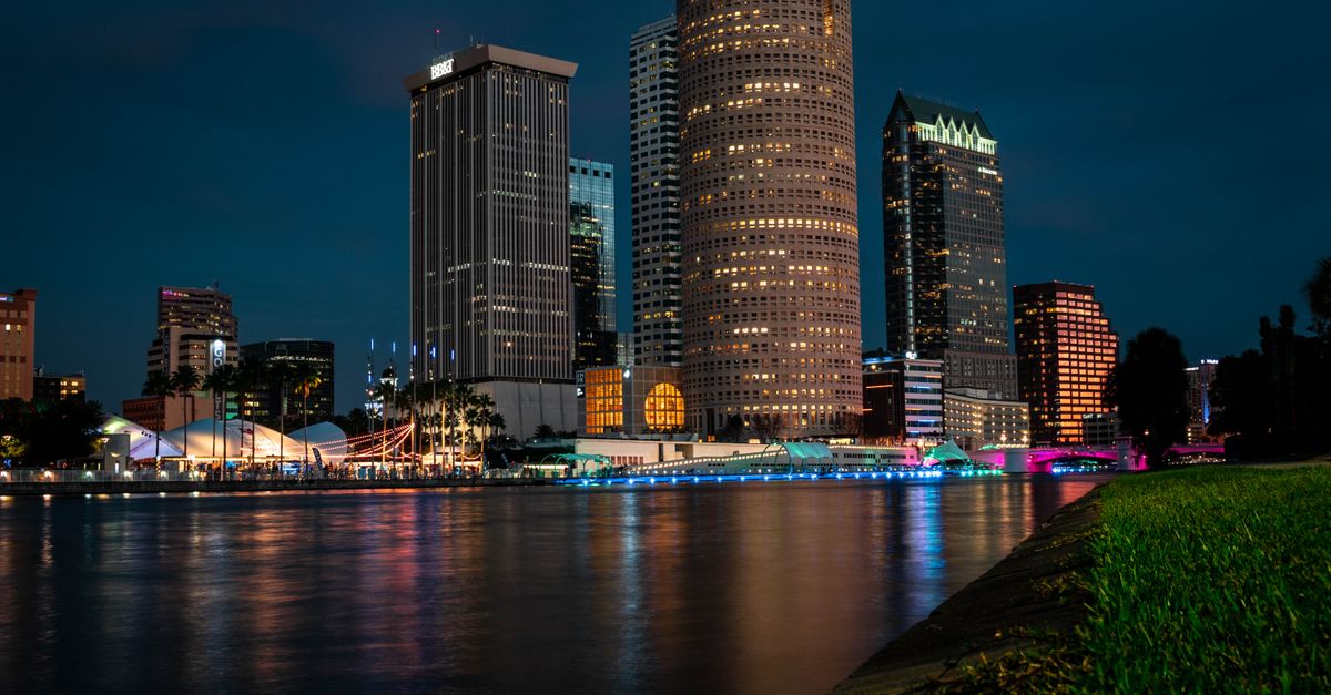 Explore Tampa's stunning evening skyline reflected on the calm river.